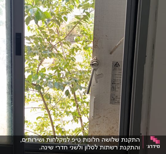 חלון אלומיניום עם נוף עצים בחוץ